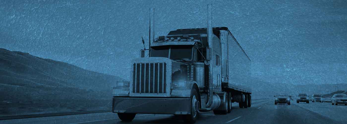 A semi truck is driving down the street.