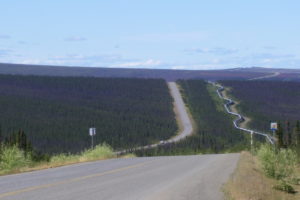 Remote highway through a forested landscape.