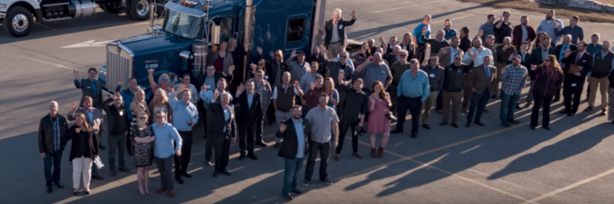 A large group of people standing in front of a truck.